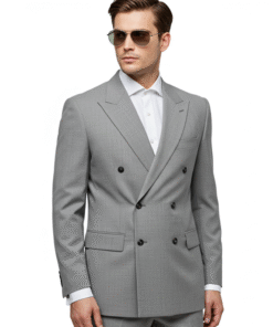 This image shows a male model standing against a plain white background, presenting a formal suit. Here's an analysis of the picture: Subject: A young man with light skin and neatly combed dark hair, styled upwards. He has a serious or neutral expression and is looking directly at the camera. His posture is symmetrical and formal, with his arms hanging straight down by his sides. Attire: Color: The suit is a solid light grey, a classic and versatile color for formal wear. Jacket (Blazer): It's a double-breasted jacket, characterized by overlapping front flaps and two parallel columns of buttons. This style is inherently more formal and traditional than a single-breasted suit. It features peak lapels, which are lapels with points that face upwards, adding to the formality and sartorial elegance of the suit. The peak lapels appear quite wide and prominent. There are six buttons visible on the front (three functional on one side, three decorative on the other), with two buttons used for closure. Two flap pockets are visible on the lower front of the jacket, and a breast pocket (welt pocket) is on the left side. The shoulders appear well-structured and possibly padded, contributing to a sharp silhouette. Shirt: He is wearing a crisp white dress shirt underneath the jacket, with the collar visible. The top button of the shirt appears to be unbuttoned, suggesting a slightly less rigid, though still formal, presentation. Trousers: The trousers match the jacket in color and fabric, completing the suit. They appear to be well-tailored with a straight or slightly tapered leg. Overall Impression: The ensemble projects a strong image of classic formality and sophistication. The double-breasted style and peak lapels indicate a refined and traditional approach to suiting. The light grey color keeps it contemporary while maintaining its formal appeal. This suit would be suitable for business formal occasions, weddings, or other significant events where a polished and distinguished appearance is desired.